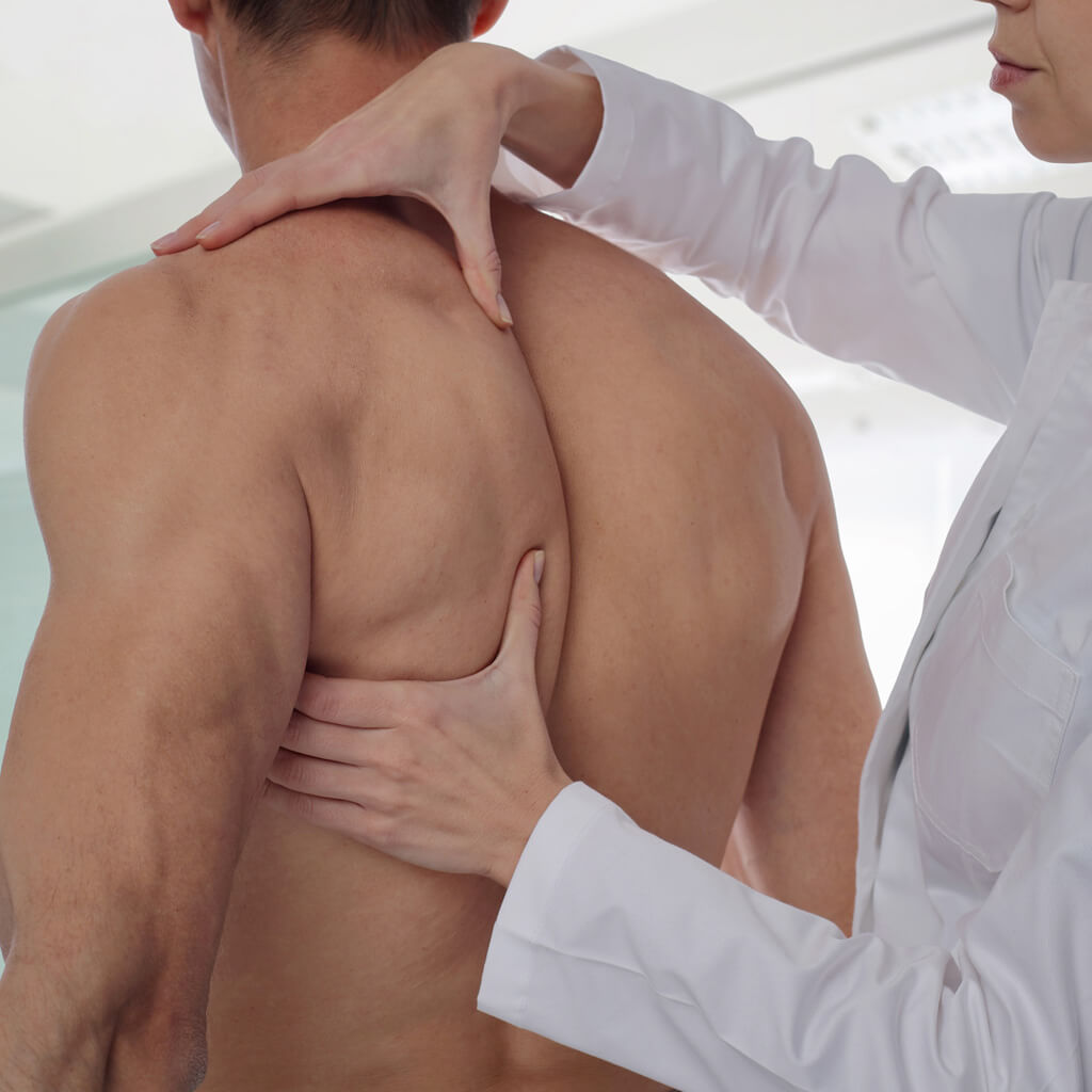 Aufbaukurs Orthopädische-Kinesiologie- Alexandra Sommer- Therapeutin arbeite an männlichem Rücken