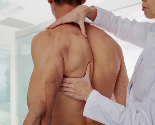 Aufbaukurs Orthopädische-Kinesiologie- Alexandra Sommer- Therapeutin arbeitet an männlichem Rücken